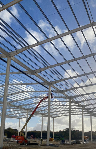 Construction site showing the steel frame structure of a large building under construction.