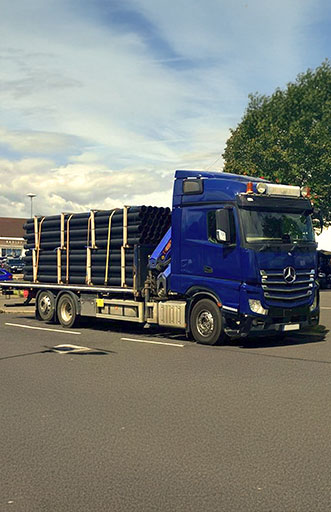 An image of a lorry carrying pipes.